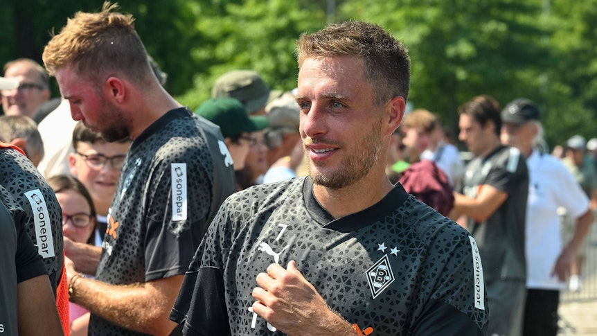 Patrick Herrmann gibt Gladbach-Fans Autogramme.
