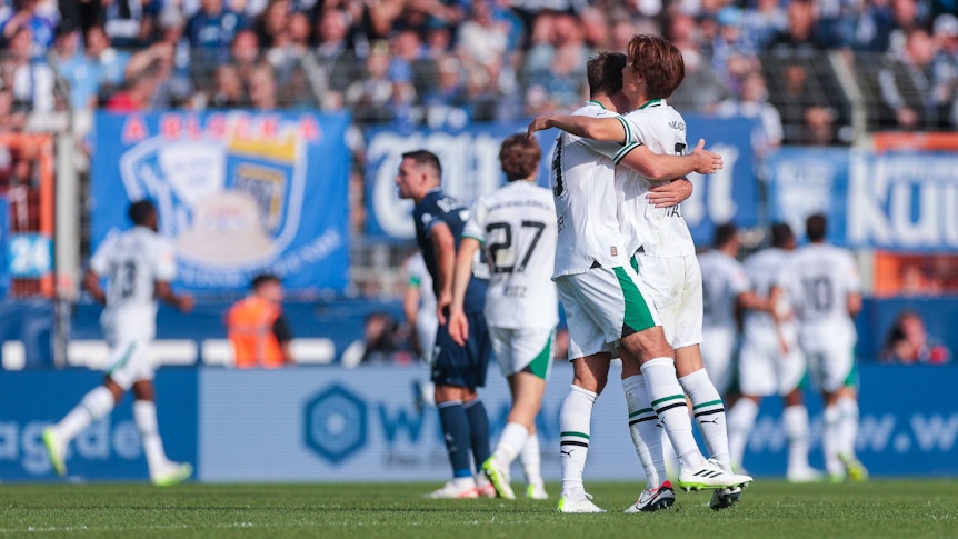 Ko Itakura und Maximilian Wöber liegen sich nach einem Borussia-Tor in den Armen.