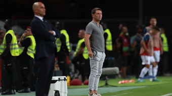 Luc Holtz steht neben Roberto Martinez am Spielfeldrand.