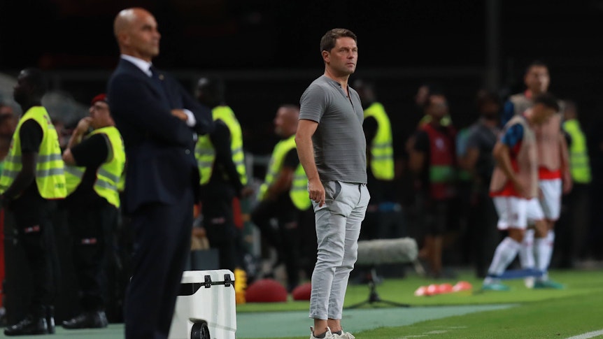 Luc Holtz steht neben Roberto Martinez am Spielfeldrand.