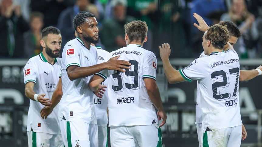 Spieler von Borussia Mönchengladbach, darunter drei Neuzugänge, klatschen sich gegenseitig ab.