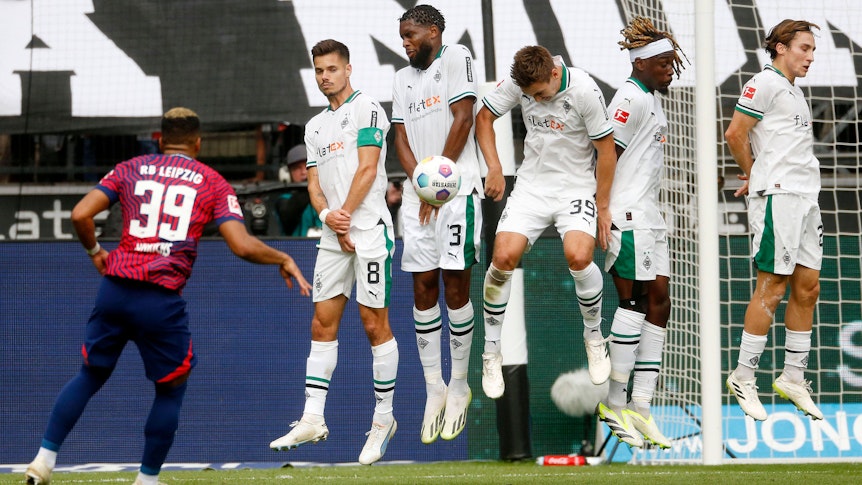 ! Benjamin Henrichs von RB Leipzig schießt einen Freistoß in die Mauer, den Max Wöber mit dem Kopf abblockt.
