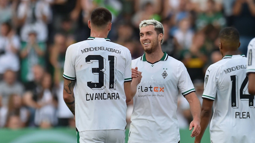 Tomas Cvancara und Joe Scally klatschen sich lächelnd ab.
