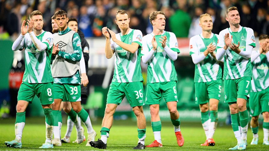 Spieler von Werder Bremen applaudieren ihren Fans.
