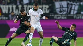 Franck Honorat versucht, den Ball gegen zwei Spieler von Werder Bremen zu behaupten.