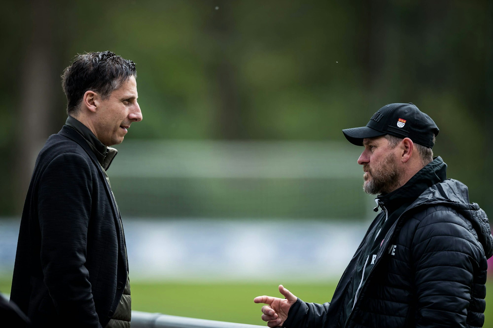 Steffen Baumgart und Christian Keller sprechen am Rande eines Trainings am Geißbockheim.