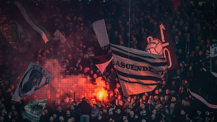 Die Fans von Borussia Mönchengladbach zünden ein Bengalo.