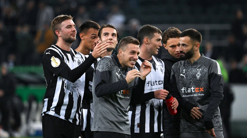Spieler von Borussia Mönchengladbach freuen sich und lachen.