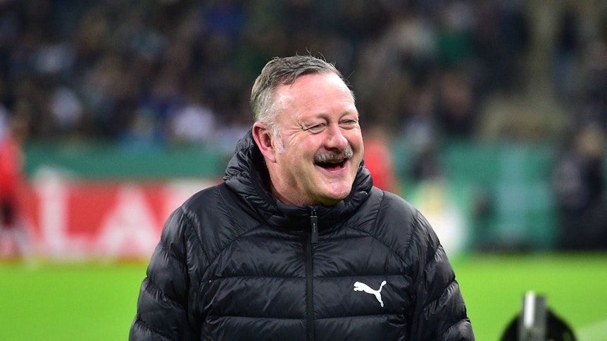 Roland Virkus lacht am Spielfeldrand.