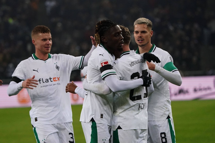 Manu Koné und Julian Weigl herzen den Torschützen Robin Hack nach einem Tor.