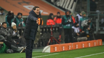 Trainer von Borussia Mönchengladbach dirigiert während eines Heimspiels an der Seitenlinie.
