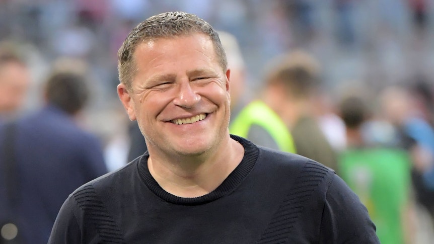 Max Eberl lächelt am Spielfeldrand.