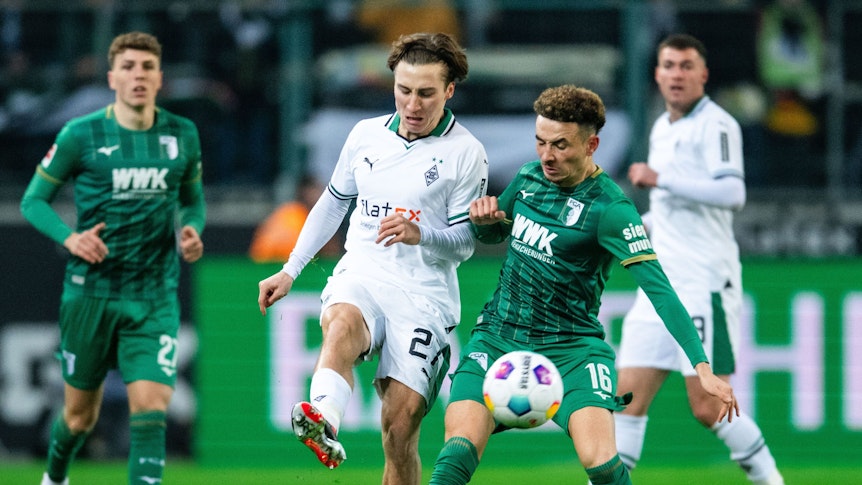 Gladbachs Rocco Reitz (l.) und Augsburgs Ruben Vargas kämpfen um den Ball.