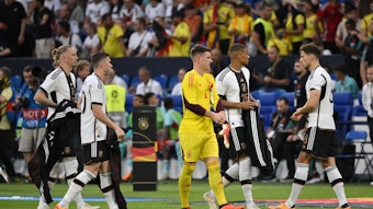 Deutsche Nationalspieler geben ihre Aufwärmjacken ab.