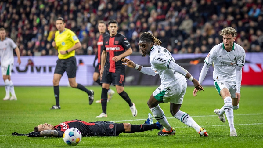 Manu Koné und Robin Hack blicken auf den Ball.