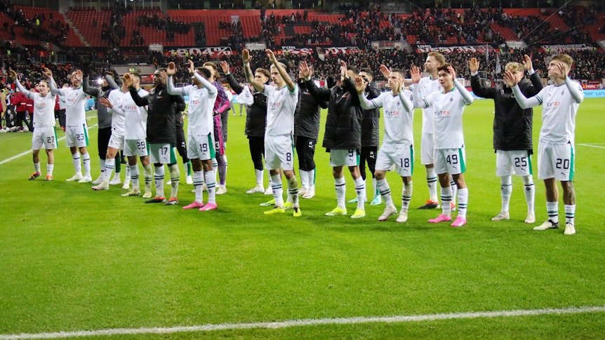 Die Borussia-Spieler vor dem Gästeblock in Leverkusen.