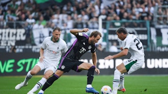 Joe Scally und Marvin Friedrich versuchen, Harry Kane vom Ball zu trennen.