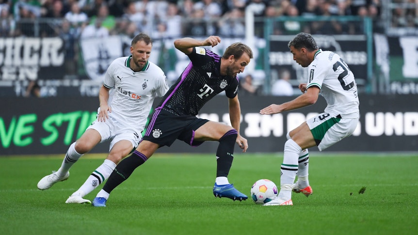 Joe Scally und Marvin Friedrich versuchen, Harry Kane vom Ball zu trennen.