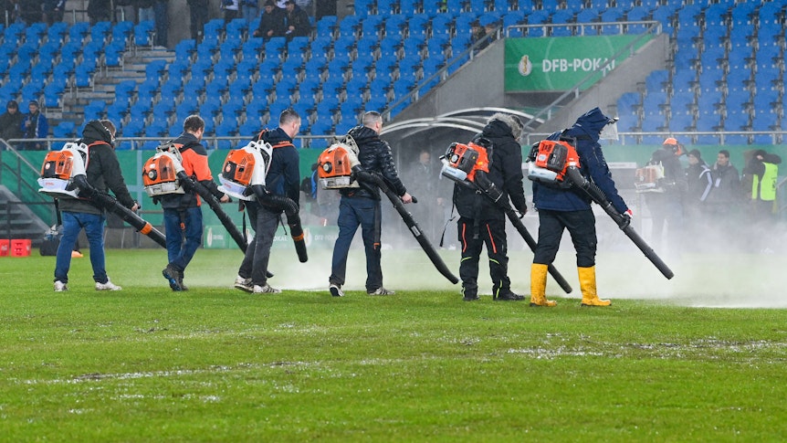 Saarbrücker Stadionmitarbeiter mit Laubbläsern.