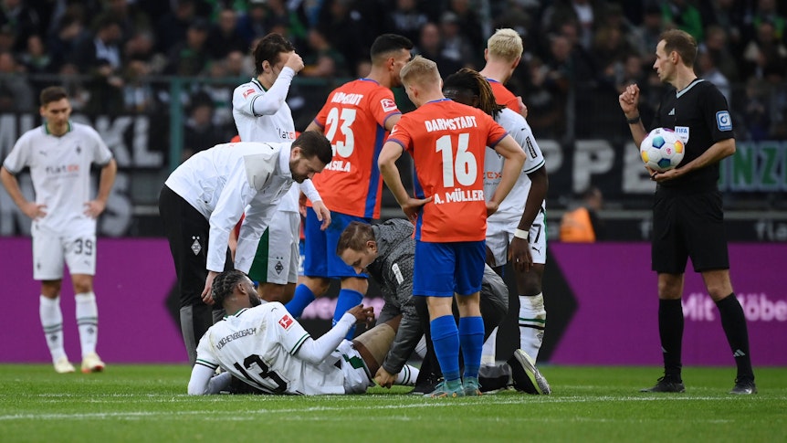 Jordan Siebatcheu wird auf dem Rasen im Borussia-Park behandelt.