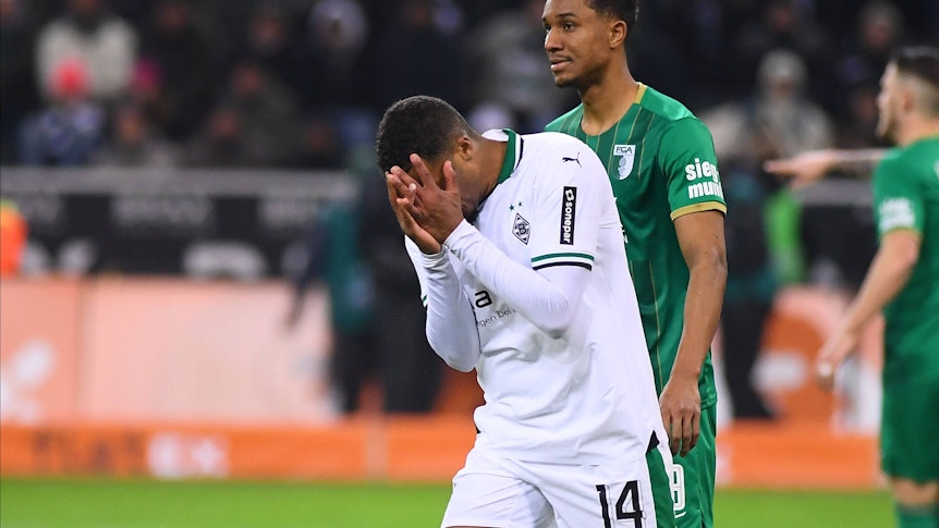 Alassane Plea vergräbt sein Gesicht in seinen Händen.