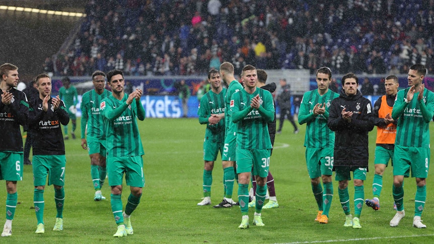 Spieler von Borussia Mönchengladbach stehen klatschend vor den Fans.