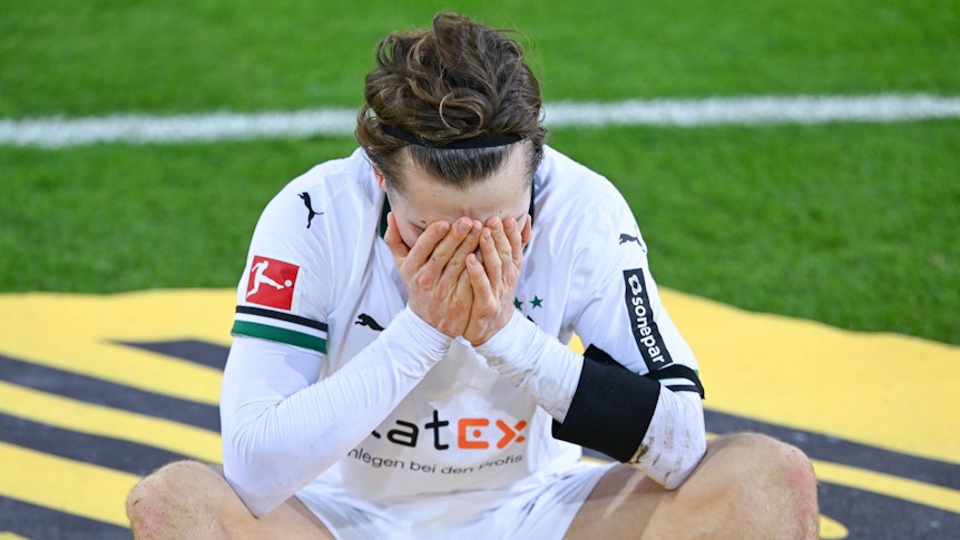 Rocco Reitz hält sich die Hand vor das Gesicht.