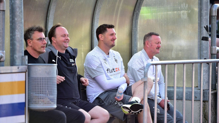 Steffen Korell, Mario Vossen, Nils Schmadtke und Roland Virkus sitzen auf einer Bank.