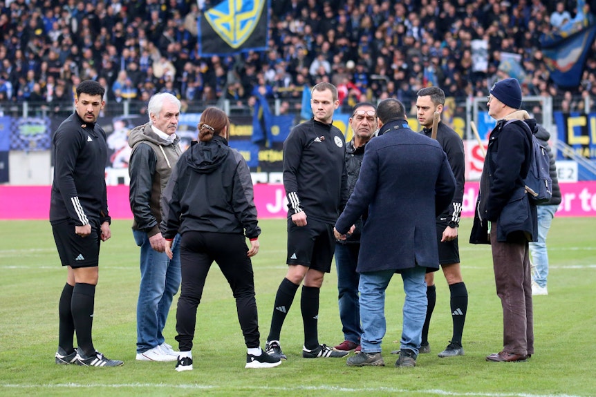 Schiedsrichter Robin Braun mit skeptischem Blick bei der Platzbegehung.