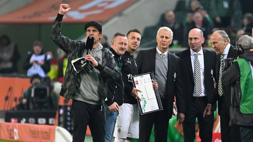 Mehrere Borussia-Funktionäre und Patrick Herrmann stehen auf dem Platz.