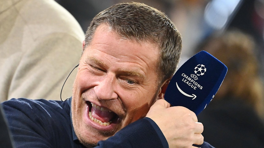 Max Eberl hält ein Mikrofon in der Hand.