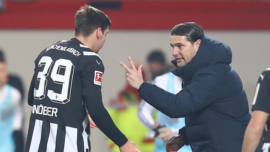 Gerardo Seoane hält Maximilian Wöber im schwarz-weißen Ausweichtrikot drei Finger vor das Gesicht.