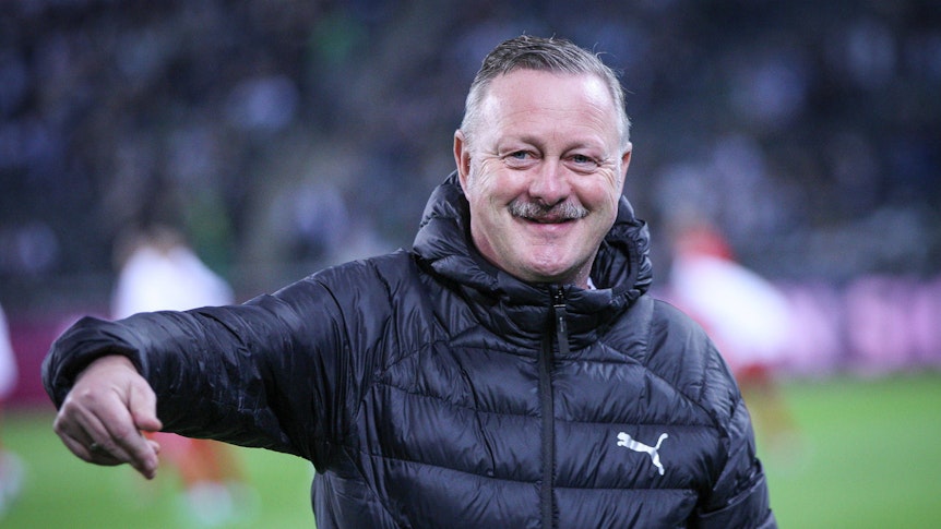 Roland Virkus grinst am Spielfeldrand.