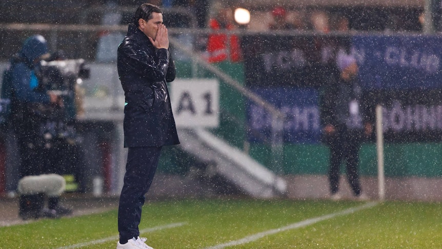 Gerardo Seoane steht im Regen und hält sich die Hände vor das Gesicht.