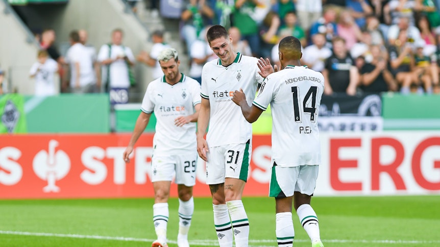 Zwei Spieler von Borussia Mönchengladbach klatschen sich gegenseitig ab.