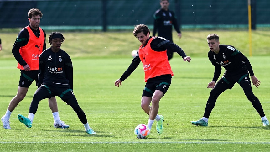 Jonas Hofmann im Training mit dem Ball. Yvandro Borges Sanches und Oscar Fraulo versuchen ihn zu stoppen.