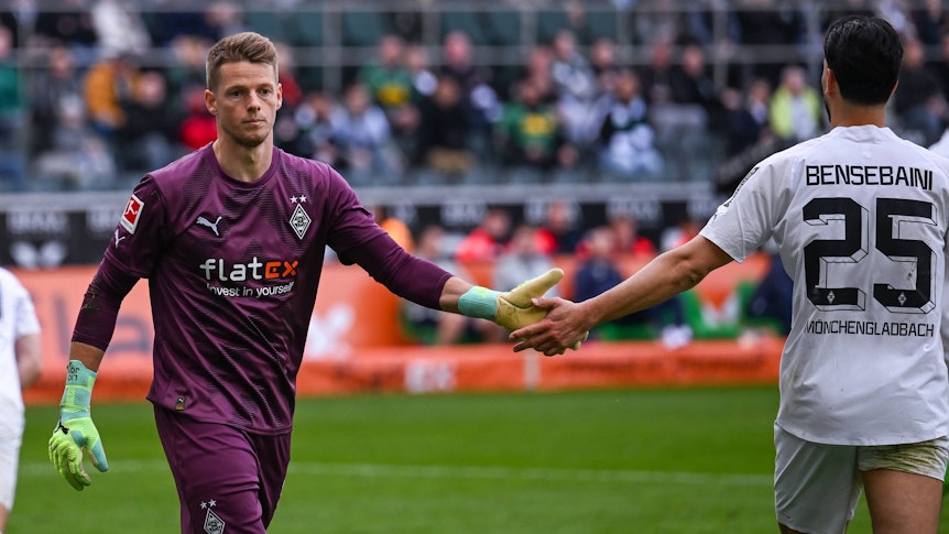 Jonas Omlin und Ramy Bensebaini klatschen sich ab.