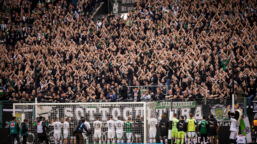 Die Fans von Borussia Mönchengladbach feiern ihre Mannschaft.