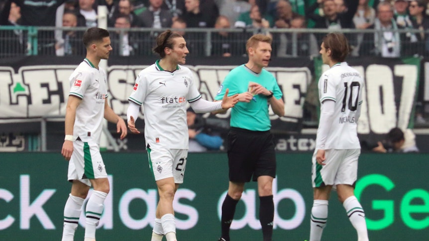 Julian Weigl, Rocco Reitz und Flo Neuhaus im Austausch mit Schiedsrichter Christian Dingert.