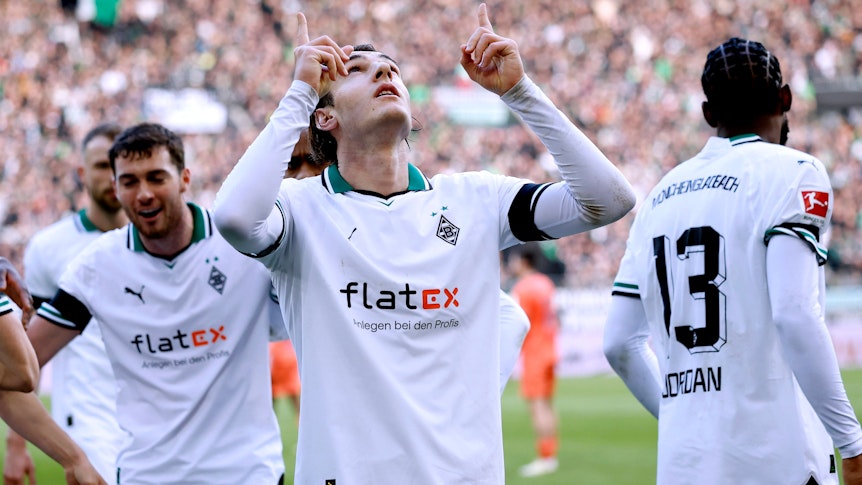 Florian Neuhaus zeigt in den Himmel.