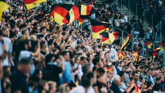 Deutschland Fans schwenken die Fahnen im Borussia-Park.