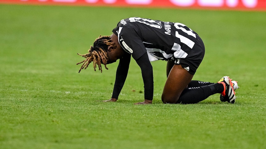Manu Koné krümmt sich auf dem Rasen.