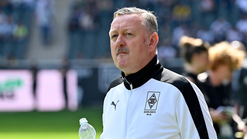 Sport-Chef von Borussia Mönchengladbach mit einer Wasserflasche in der Hand.