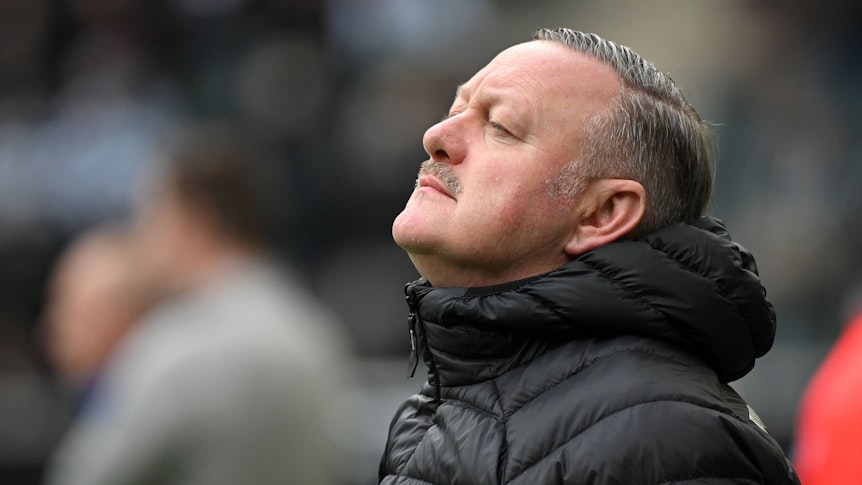Roland Virkus blickt am Spielfeldrand nach oben.