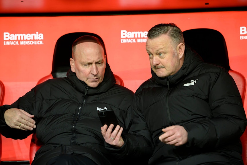 Stephan Schippers schaut auf das Smartphone von Roland Virkus.