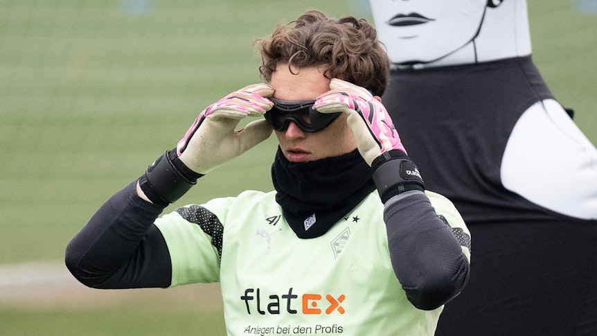 Jan Olschowsky zieht sich eine Verdunklungsbrille im Training an.
