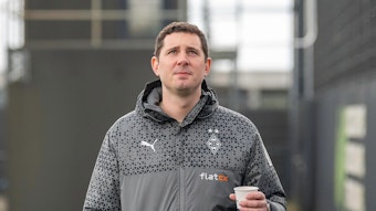 Sportdirektor von Borussia Mönchengladbach mit einem Kaffee in der Hand.