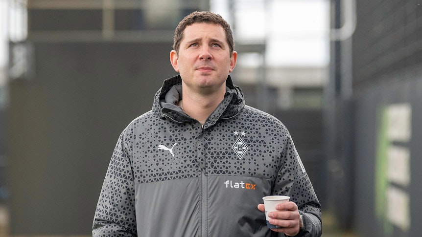 Sportdirektor von Borussia Mönchengladbach mit einem Kaffee in der Hand.