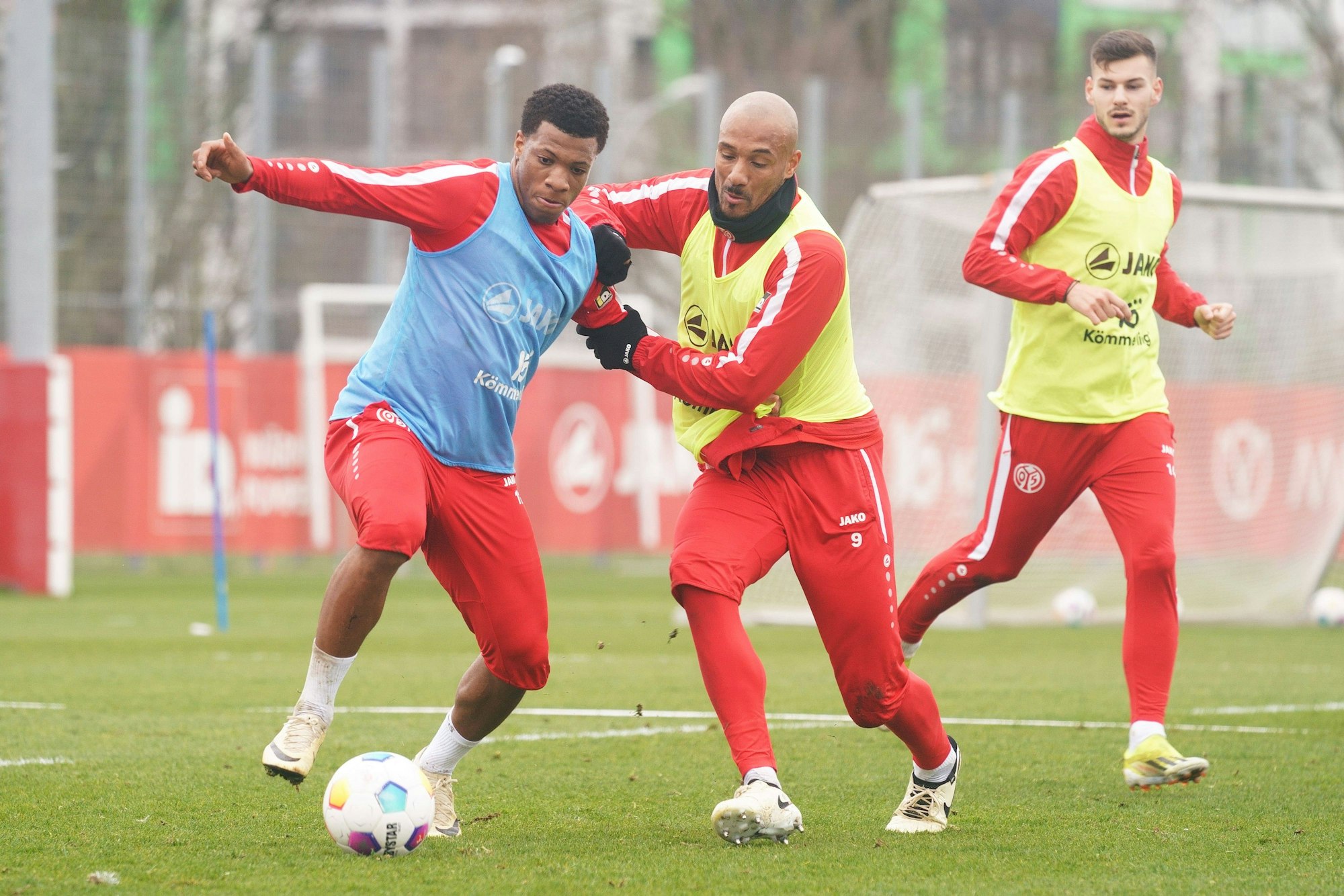 Jessic Ngankam behauptet den Ball im Mainz-Training gegen Karim Onisiwo. Tom Krauß schaut zu.