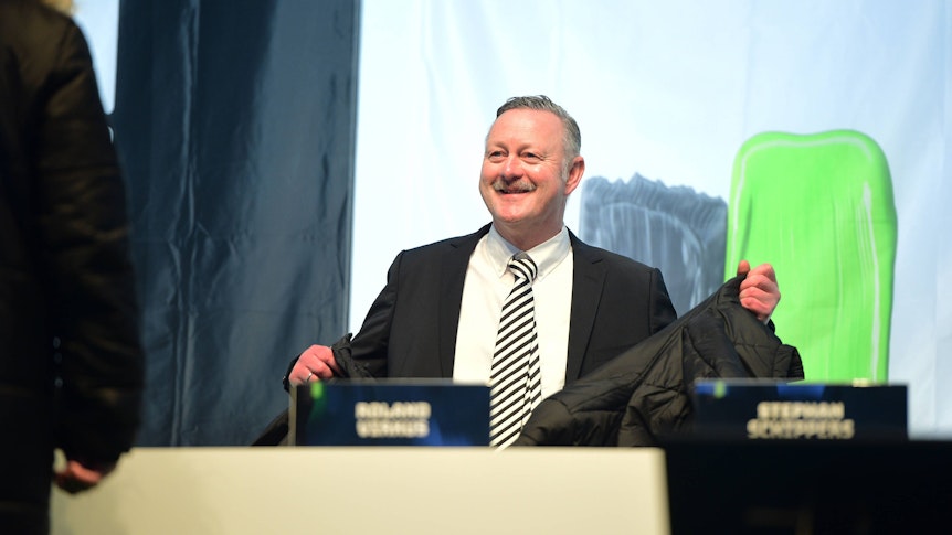 Roland Virkus lächelt auf dem Podium.